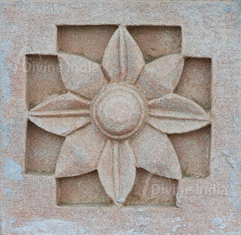 Wall sculpture from a stone in the form of a flower on walls