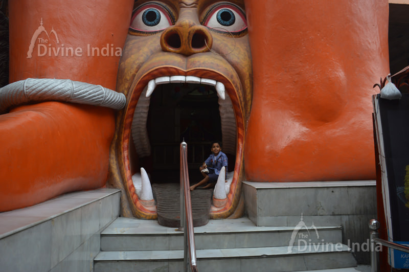 The entrance of the temple has an open mouth Rakshas or a monster in a slain condition at the death bed at 108 Feet Hanuman Temple