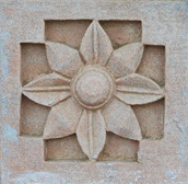 Wall sculpture from a stone in the form of a flower on walls