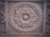 Wall sculpture from a stone in the form of a flower on walls