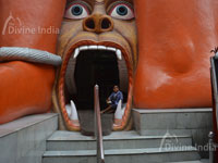 The entrance of the temple has an open mouth Rakshas or a monster in a slain condition at the death bed at 108 Feet Hanuman Temple